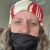 A white woman wearing a black snood and a red and white headband